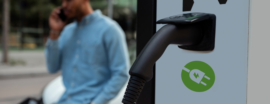 Close-up view of an EV Charging Station in Sebastopol with a person in the background.