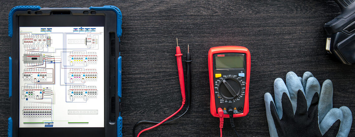 Tools and a digital schematic used for electrical inspections in Sebastopol, including a tablet, multimeter, and gloves.