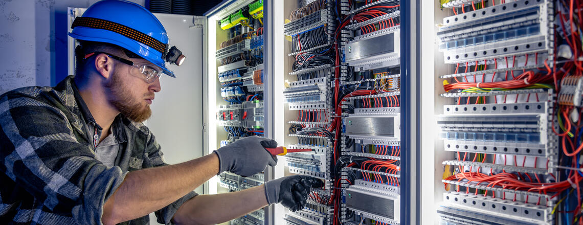 Electrician performing electrical upgrades in Santa Rosa, working on a complex panel system.