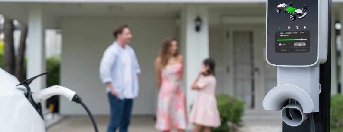 Best EV charger for home installed in a driveway with a family in the background.